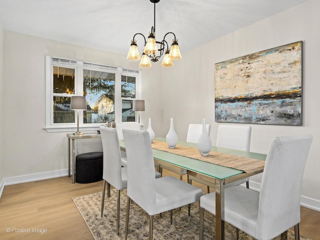 dining space featuring an inviting chandelier and light wood-type flooring