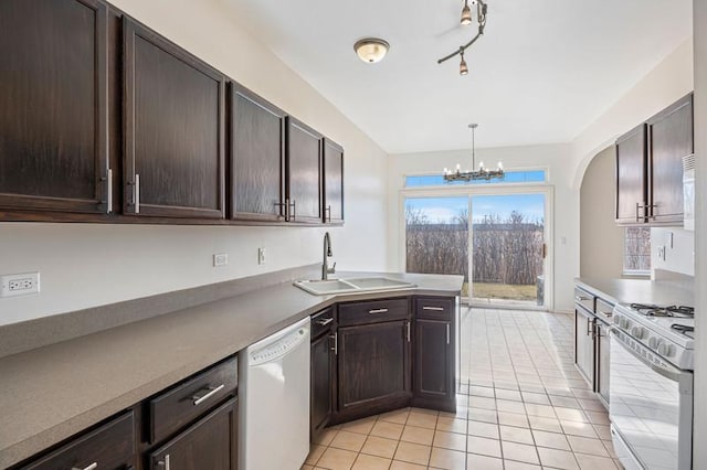 kitchen with sink, dark brown cabinets, hanging light fixtures, light tile patterned floors, and white appliances