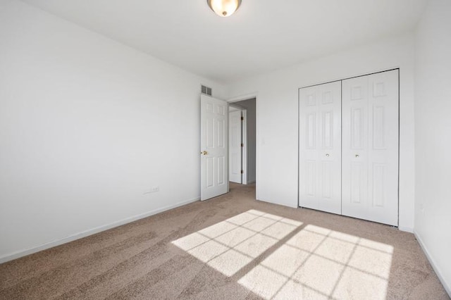 unfurnished bedroom featuring carpet flooring and a closet