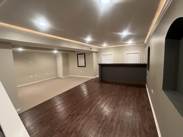 basement with ornamental molding and dark hardwood / wood-style floors