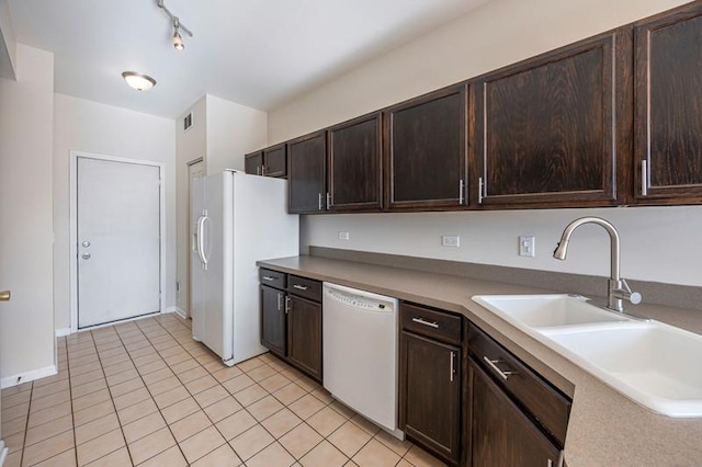 kitchen featuring sink, white appliances, dark brown cabinets, and light tile patterned flooring