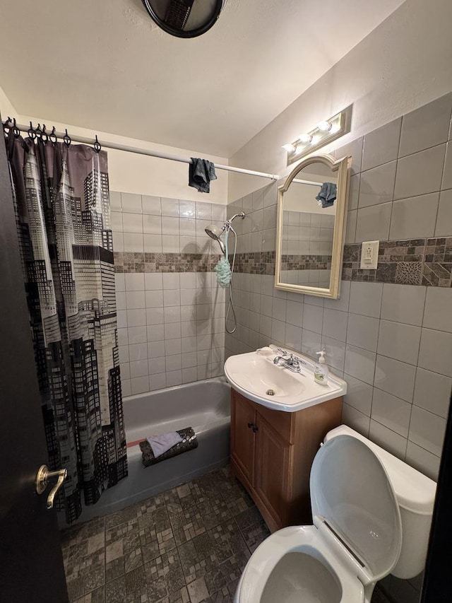 full bathroom with tile walls, vanity, toilet, and shower / bath combo with shower curtain