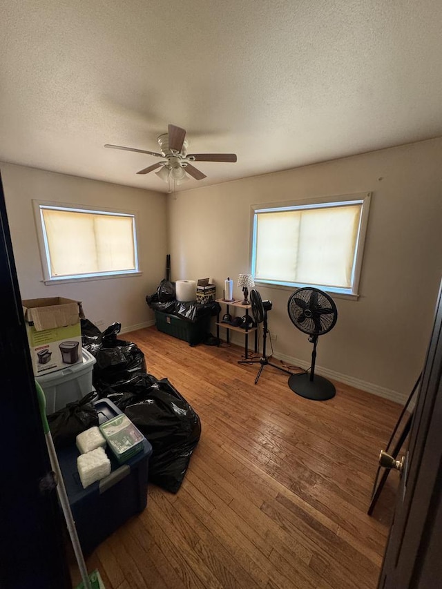 miscellaneous room with hardwood / wood-style flooring, ceiling fan, a healthy amount of sunlight, and a textured ceiling