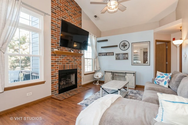 living room featuring lofted ceiling, hardwood / wood-style floors, a fireplace, and ceiling fan