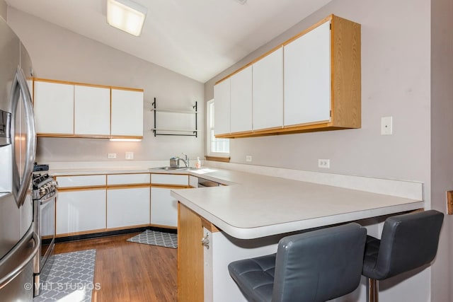 kitchen featuring white cabinetry, sink, stainless steel appliances, and kitchen peninsula