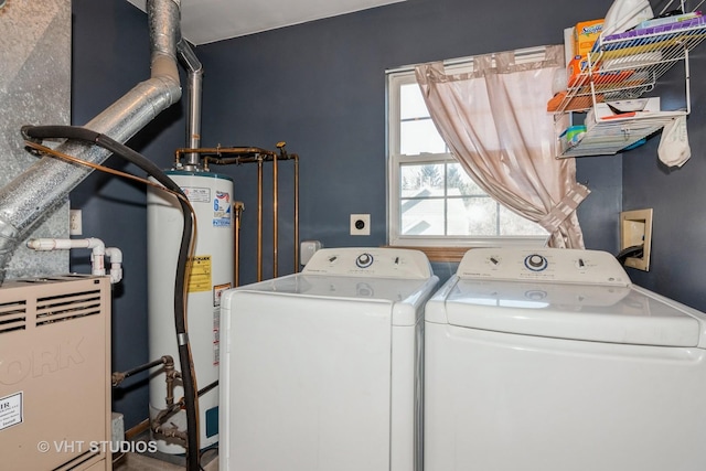 clothes washing area featuring water heater and washer and clothes dryer