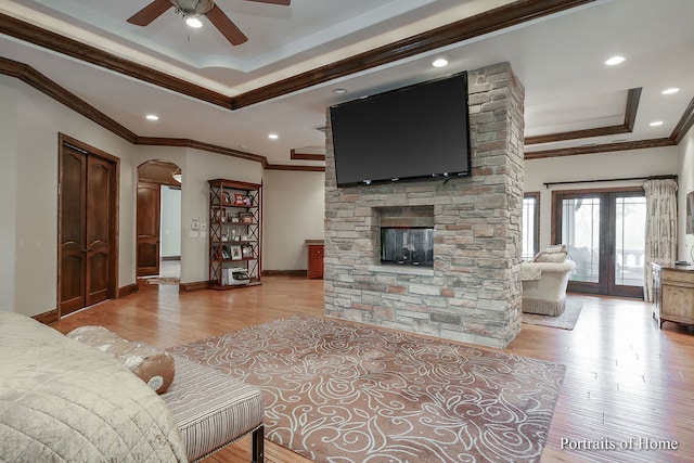 living room with crown molding, a fireplace, and light hardwood / wood-style floors