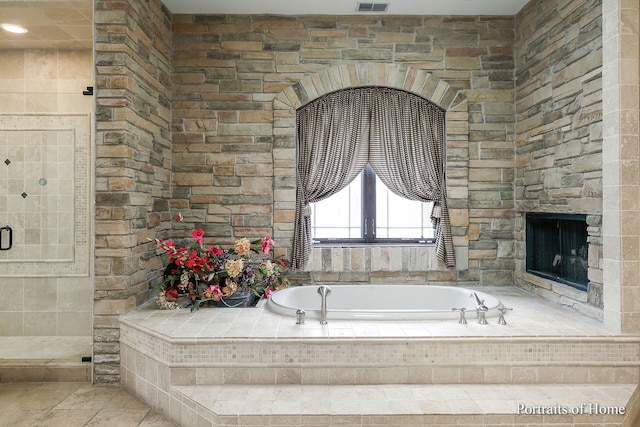 bathroom with plus walk in shower and a fireplace