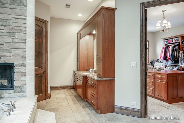 bathroom with vanity, a fireplace, and a chandelier