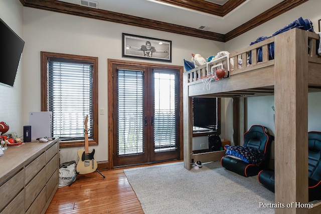 bedroom with ornamental molding, french doors, and light wood-type flooring