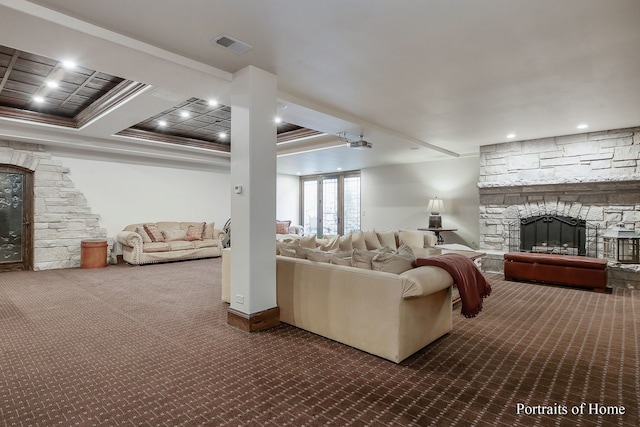 living room featuring crown molding, dark carpet, and a fireplace