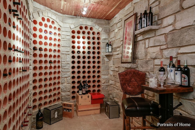 wine room featuring light tile patterned flooring and wooden ceiling