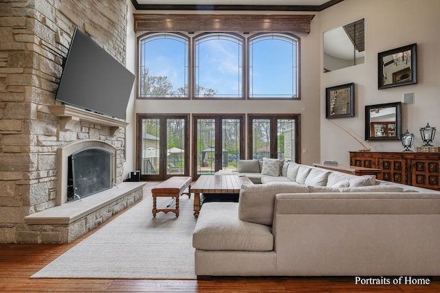 living room with crown molding, a fireplace, and hardwood / wood-style floors