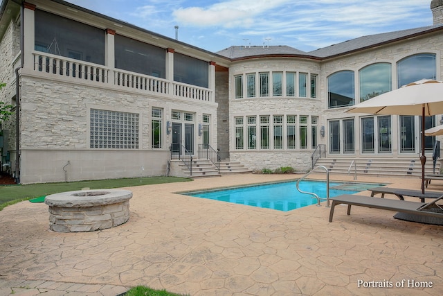 view of swimming pool featuring an outdoor fire pit and a patio area