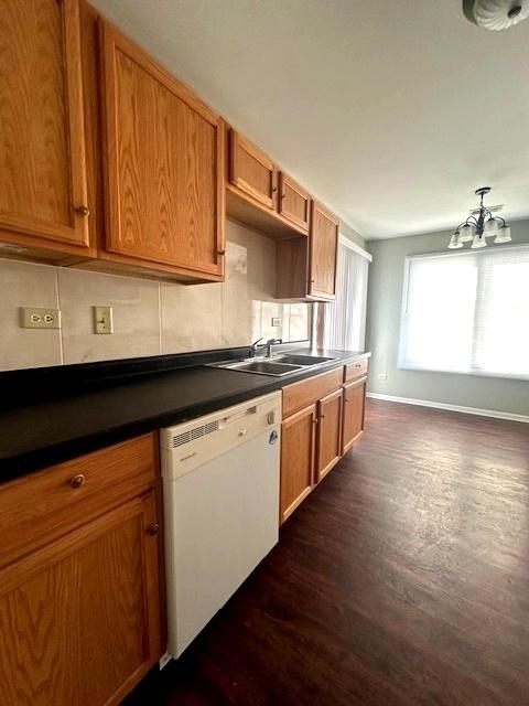 kitchen with dark hardwood / wood-style floors, sink, backsplash, and white dishwasher