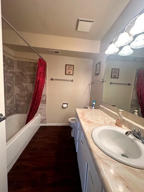 full bathroom with vanity, hardwood / wood-style flooring, toilet, and shower / bath combo with shower curtain