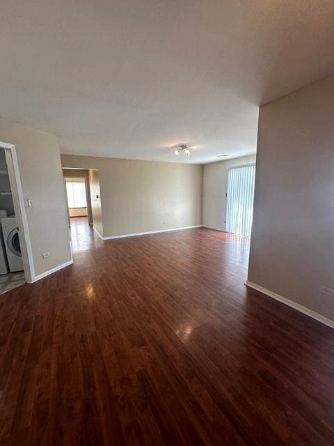 empty room featuring dark hardwood / wood-style flooring and washer / dryer