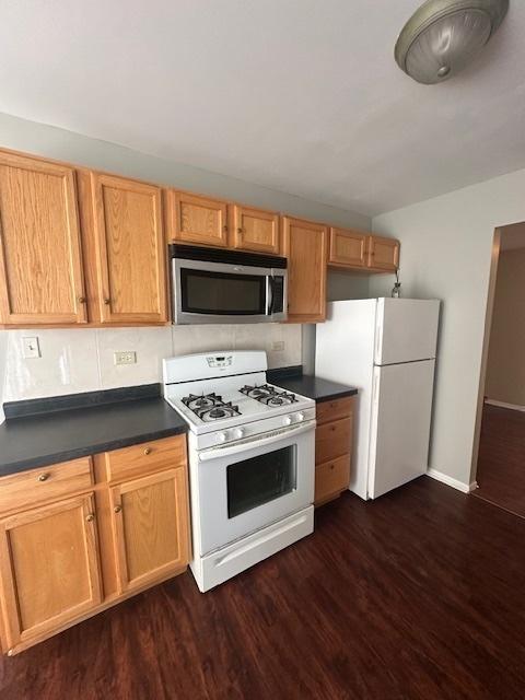 kitchen featuring dark hardwood / wood-style flooring and white appliances