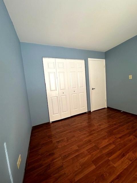 unfurnished bedroom with dark wood-type flooring