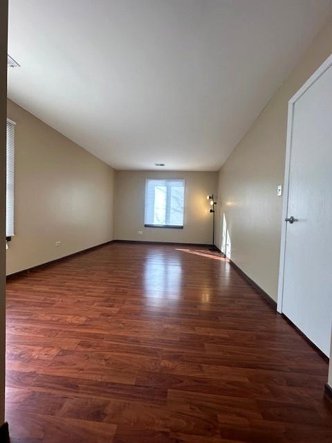 unfurnished room with dark wood-type flooring