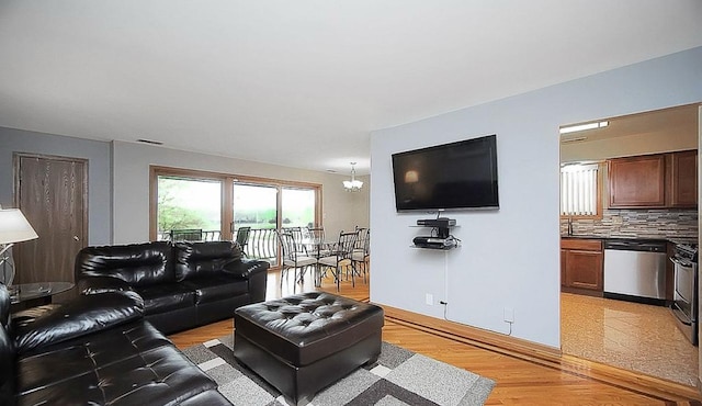 living room with a notable chandelier and light wood-type flooring