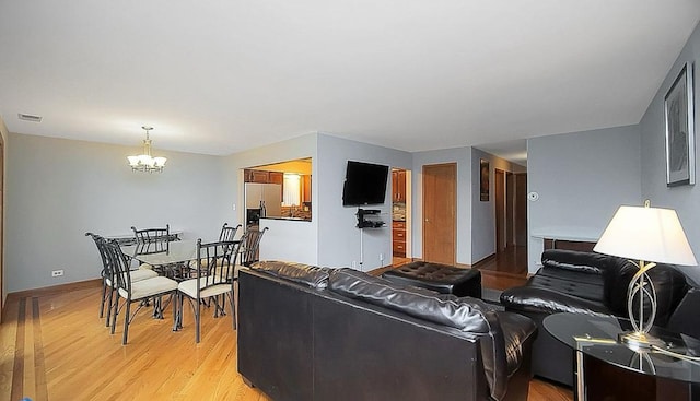 living room featuring an inviting chandelier and light hardwood / wood-style flooring