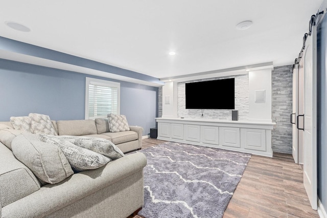 living room with light hardwood / wood-style floors and a barn door