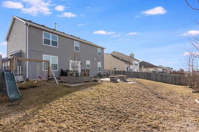 back of house with a yard, a playground, and a patio