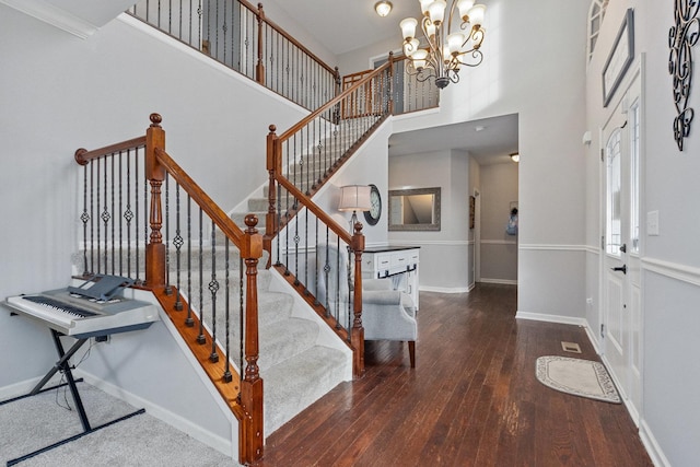 entrance foyer with an inviting chandelier, dark wood-type flooring, and a high ceiling