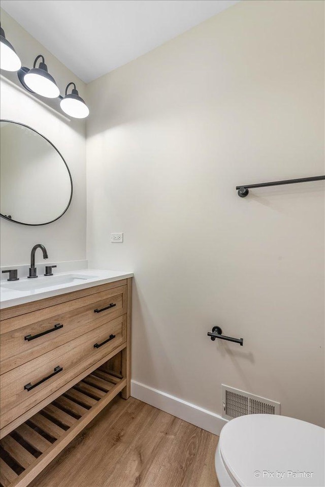 bathroom featuring vanity, toilet, and hardwood / wood-style floors