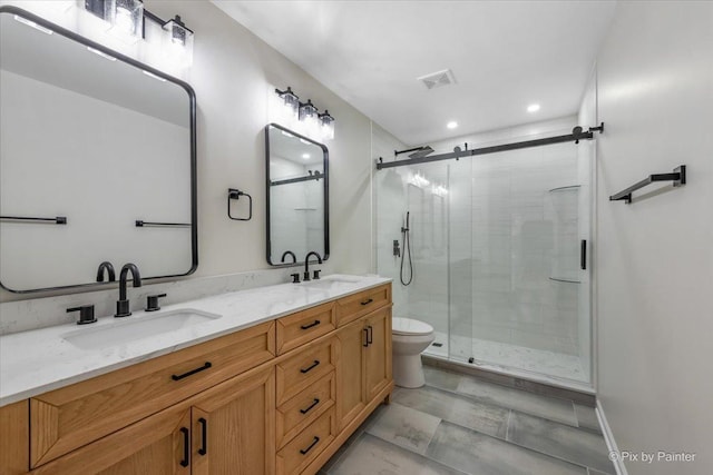 bathroom with vanity, a shower with shower door, and toilet