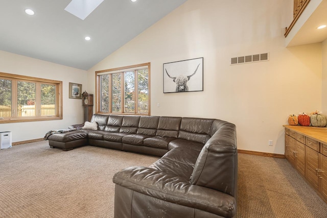 living room featuring carpet, high vaulted ceiling, and a skylight