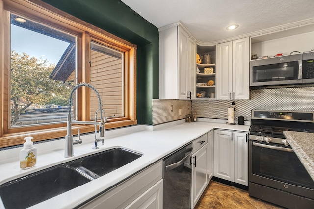 kitchen featuring stainless steel appliances, sink, white cabinets, and decorative backsplash