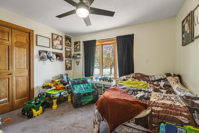 bedroom featuring a textured ceiling, carpet floors, and ceiling fan