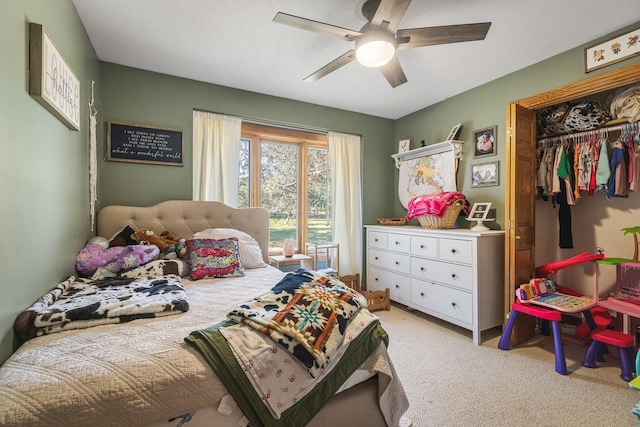 carpeted bedroom with ceiling fan and a closet