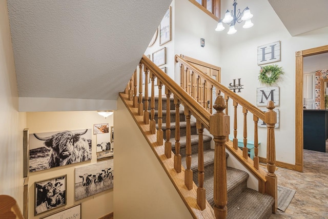 stairway featuring a high ceiling and a notable chandelier