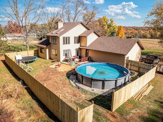 view of pool featuring a trampoline and a yard