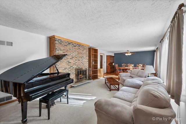 living room featuring ceiling fan, light carpet, a brick fireplace, and a textured ceiling