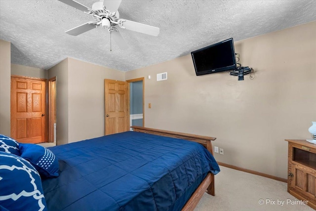 bedroom featuring light colored carpet, a textured ceiling, and ceiling fan