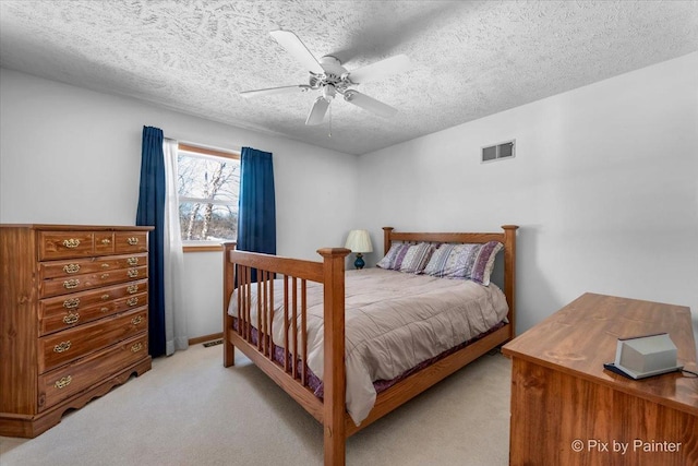 bedroom featuring light carpet, a textured ceiling, and ceiling fan