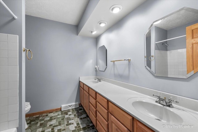 bathroom with vanity, a shower, and toilet