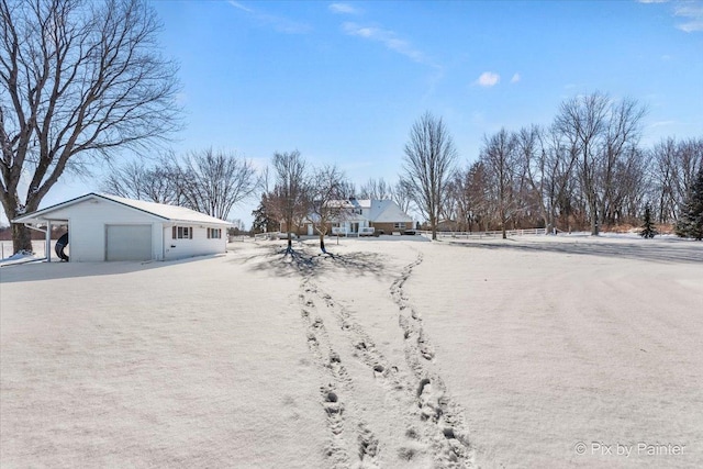 snowy yard with a garage