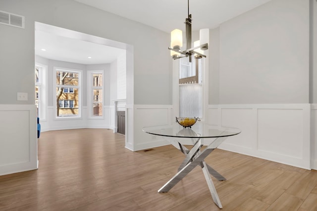 unfurnished dining area featuring an inviting chandelier and light wood-type flooring