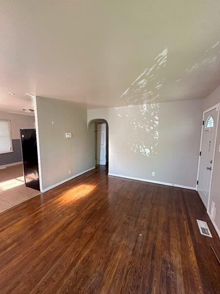 unfurnished living room with dark hardwood / wood-style floors and a wealth of natural light