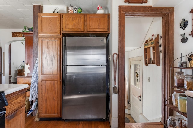 kitchen with stainless steel fridge, light hardwood / wood-style floors, and range