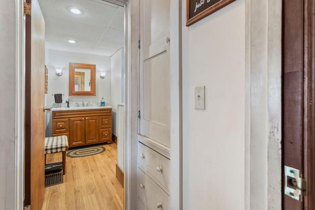 bathroom featuring vanity, hardwood / wood-style floors, and a drop ceiling