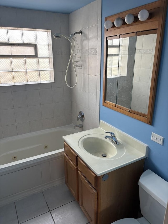 full bathroom with tile patterned flooring, tiled shower / bath, vanity, and toilet