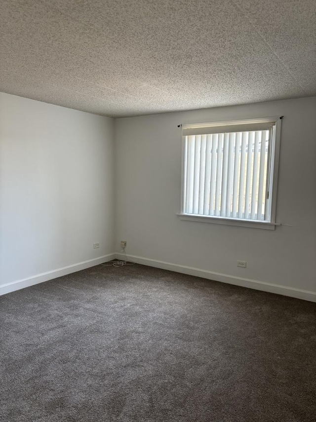 carpeted spare room with a textured ceiling