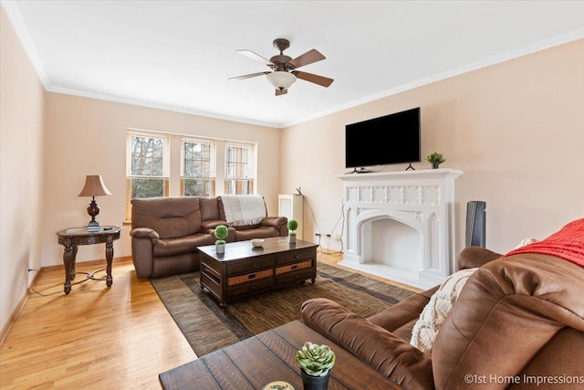 living room featuring hardwood / wood-style flooring, ceiling fan, and crown molding