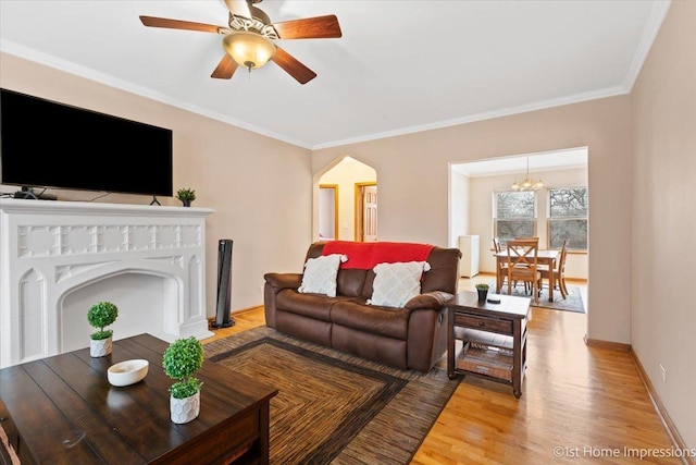 living room featuring crown molding, ceiling fan, and light hardwood / wood-style flooring